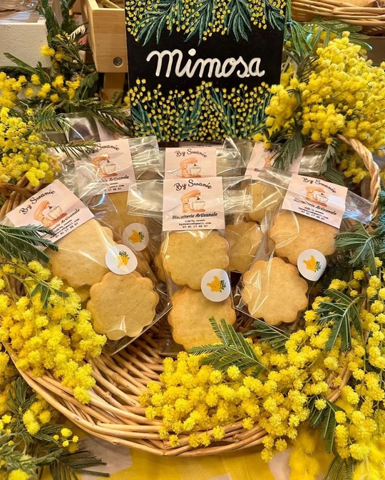 Grands biscuits sablés en sachets transparents présentés dans un panier de mimosa